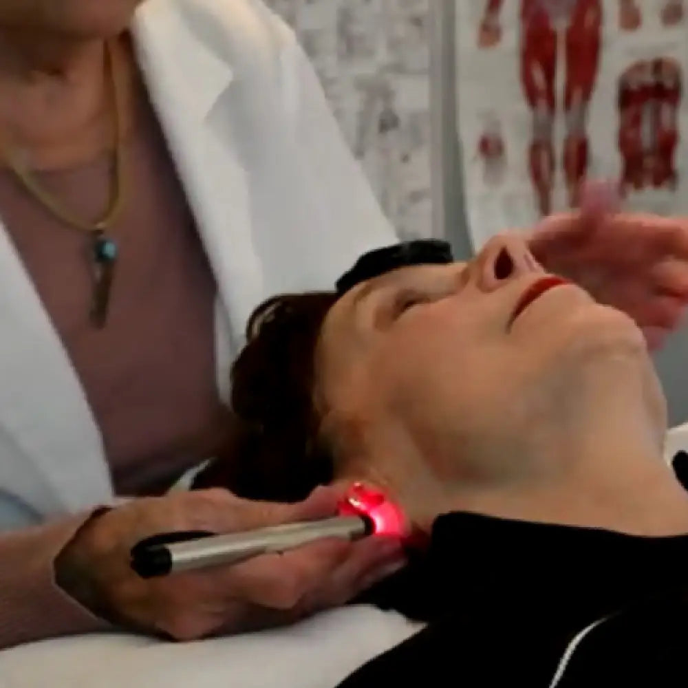 Red laser beauty device with black handle in Auricularmedicine Program