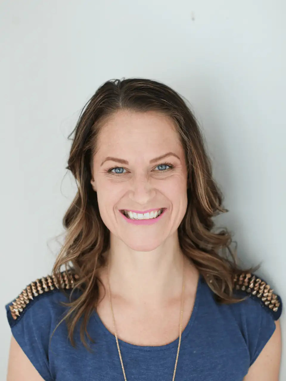 Blue t-shirt with beaded shoulder accents and gold necklace.