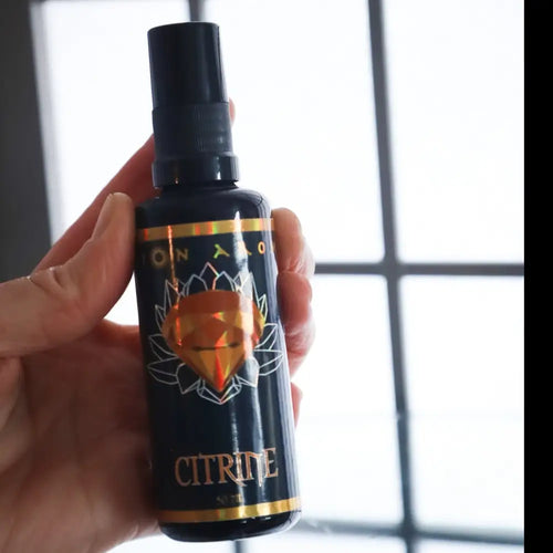 Citrine Mist spray bottle with black cap, gold accents, and glowing orange gem design