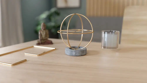 Divinity globe: minimalist gold wire globe on textured gray stone base