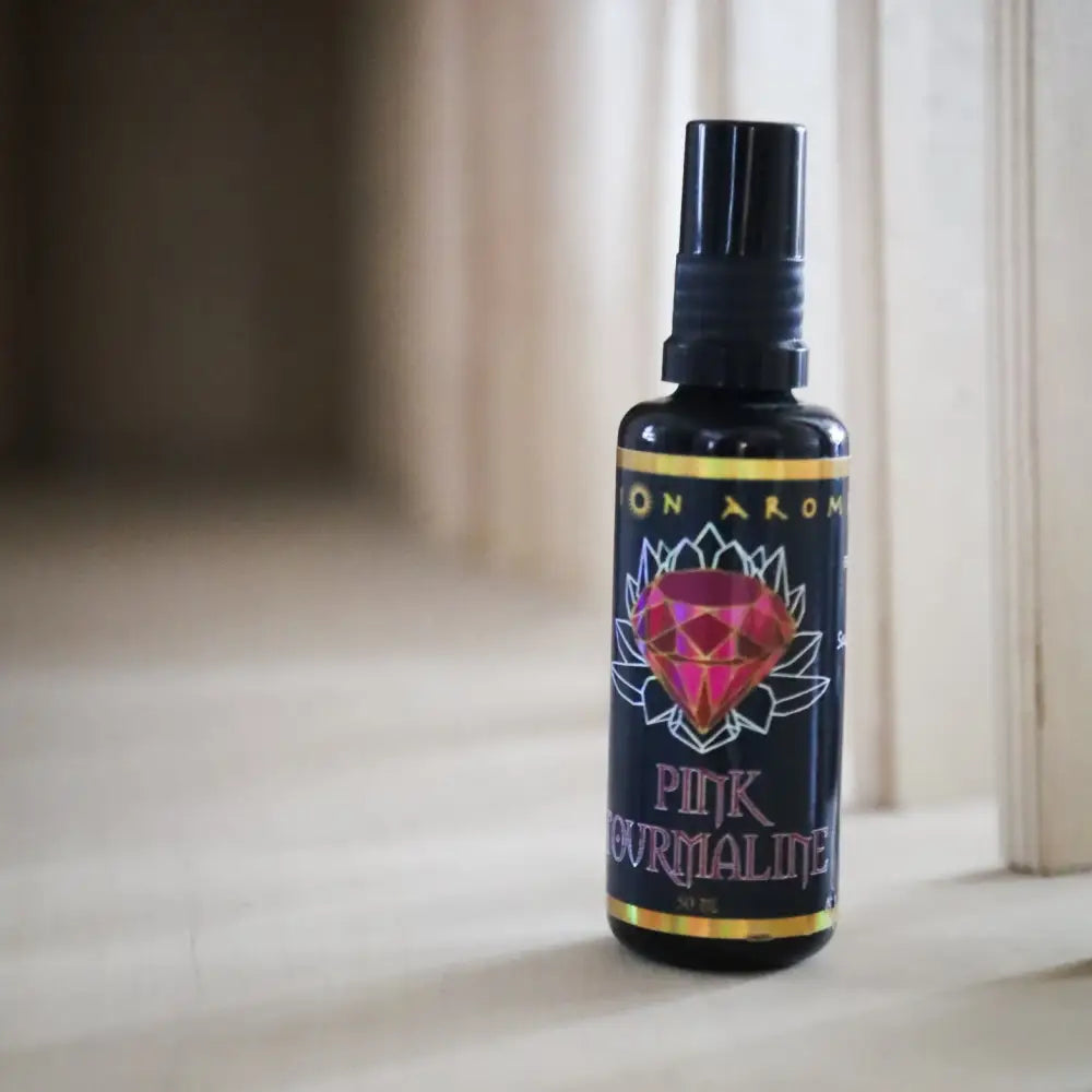 Pink tourmaline aromatherapy mist bottle with black cap and purple label