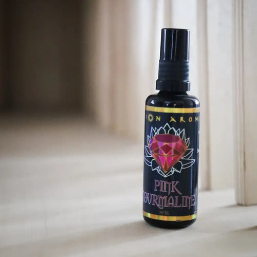 Pink tourmaline aromatherapy mist bottle with black cap and purple label