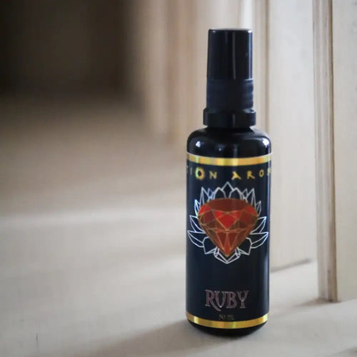Ruby Mist spray bottle with red gem label, gold accents on black background