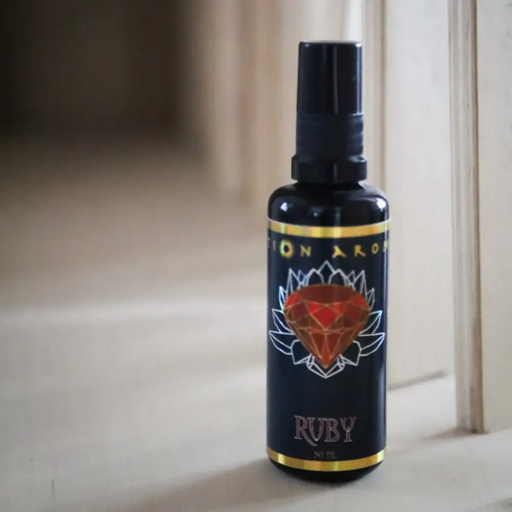 Ruby Mist spray bottle with red gem label, gold accents on black background