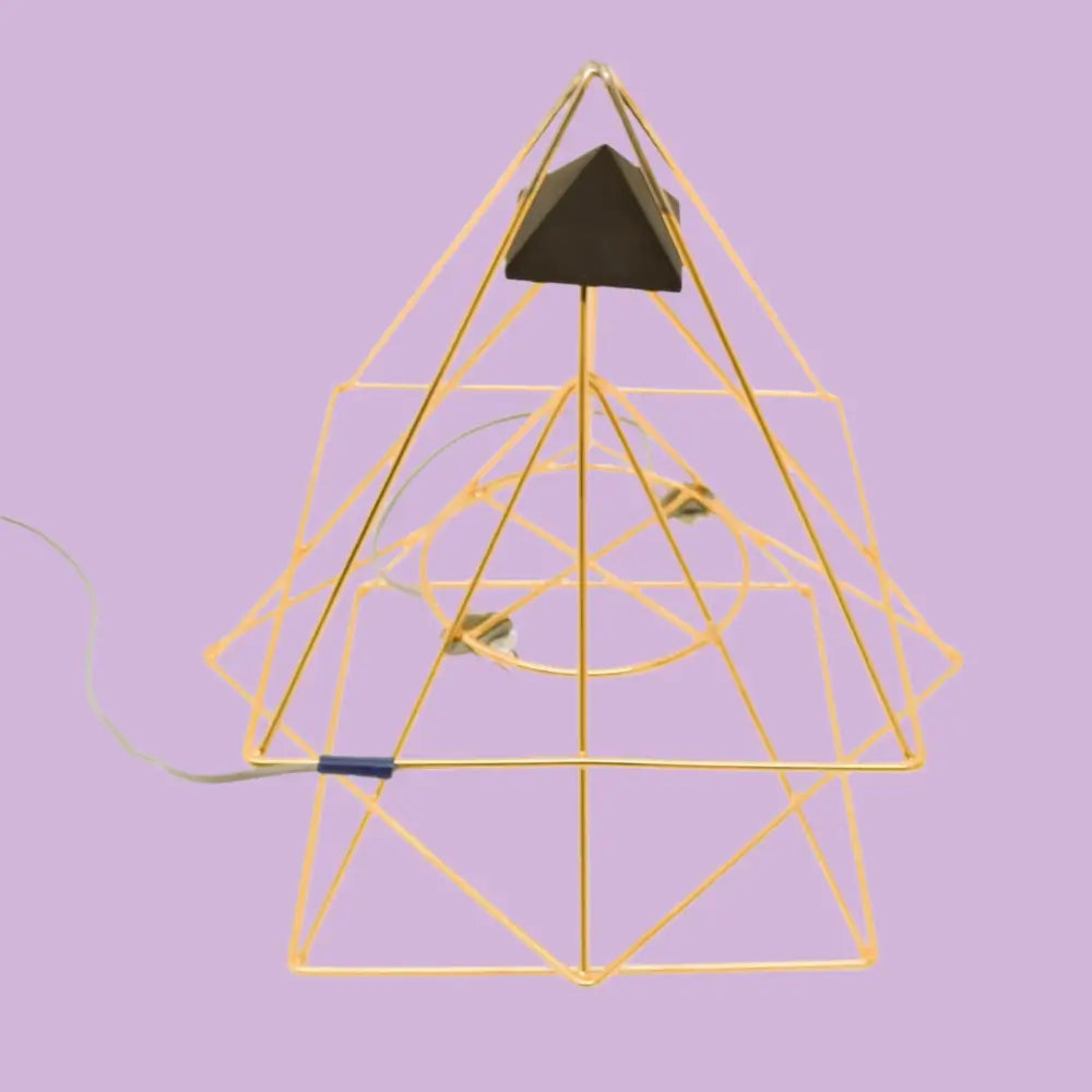 Gold pyramid-shaped wire frame with black accents and green leaves in Triple Pyramid System