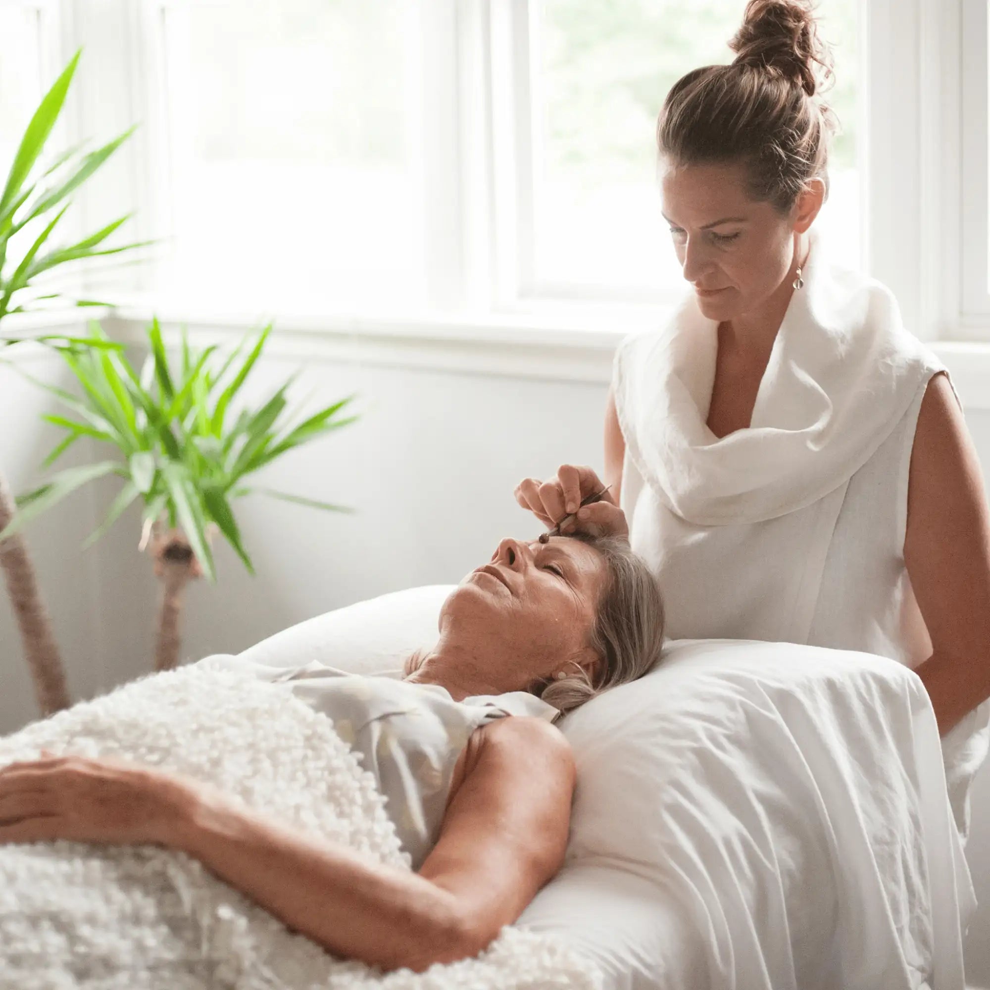 White spa bed with plush gray blanket and soft pillow